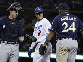 Milwaukee Brewers' Jesus Aguilar and Los Angeles Dodgers' Manny Machado have words during the 10th inning of Game 4 of the National League Championship Series baseball game Tuesday, Oct. 16, 2018, in Los Angeles.