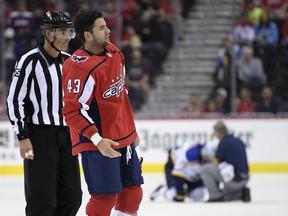 In this Sept. 30, 2018, file photo, Washington Capitals winger Tom Wilson (43) is escorted by an official off the ice after he checked St. Louis Blues centre Oskar Sundqvist, on ice at back centre, in Washington.