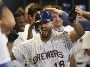In this Friday, Sept. 14, 2018, file photo, Milwaukee Brewers' Mike Moustakas is congratulated after hitting a home run during the seventh inning of a baseball game against the Pittsburgh Pirates, in Milwaukee.