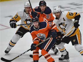 Edmonton Oilers Kailer Yamamoto (56) and Ryan Nugent-Hopkins (93) battle with Pittsburgh Penguins Kris Letang (58) and Jack Johnson (73) during NHL action at Rogers Place on Tuesday, Oct. 23, 2018.