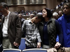 People mourn in Soldiers & Sailors Memorial Hall & Museum during a community gathering held in the aftermath of Saturday's deadly shooting at the Tree of Life Synagogue in Pittsburgh, Sunday, Oct. 28, 2018.
