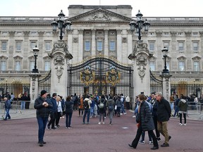Tourists outside Buckingham Palace in London. (Dominic Lipinski/PA via AP)
