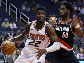 Phoenix Suns centre Deandre Ayton (22) drives on Portland Trail Blazers forward Caleb Swanigan Friday, Oct. 5, 2018, in Phoenix. (AP Photo/Rick Scuteri)