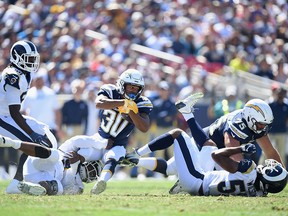Austin Ekeler #30 of the Los Angeles Chargers gets tackled by Dominique Easley #91 of the Los Angeles Rams during the second quarter of the game at Los Angeles Memorial Coliseum on Sept. 23, 2018 in Los Angeles.