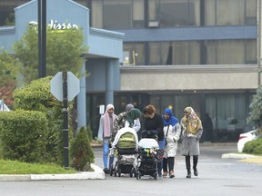 A group of women watch their children outside the Radisson hotel at Hwy 401 and Victoria Park Ave. in North York, Ont., on Tuesday.