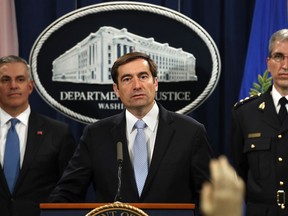 U.S. Assistant Attorney General for National Security John Demers, centre, answers questions during a news conference at the Justice Department in Washington, Thursday, Oct. 4, 2018.