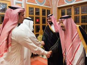 In this photo released by Saudi Press Agency, SPA, Saudi King Salman, right, and Crown Prince Mohammed bin Salman, second right, receive Sahel, a family member, and Salah, a son, of Jamal Khashoggi, in Riyadh, Saudi Arabia, Tuesday, Oct. 23, 2018.