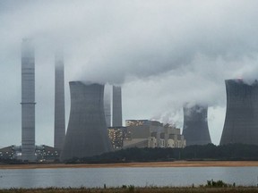 FILE - This June 1, 2014, file photo show the coal-fired Plant Scherer in operation in Juliette, Ga. Despite what President Donald Trump says, scientists have long known that what's warming the planet isn't natural. It's us. Climate scientists say Trump was wrong. There are several ways they know that more than 90 percent of climate change is caused by emissions of heat-trapping gases from activities like burning coal and natural gas for electricity, or burning gasoline, diesel and jet fuel for transportation. In other words, humans.