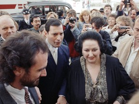 In this Monday, Oct. 10, 1988 file photo, rock star Freddie Mercury, centre left, lead singer of the pop group Queen, arrives with opera star Montserrat Caballe at the Royal Albert Hall in London to publicize their hit song 'Barcelona.' (AP Photo/Martin Cleaver, File)
