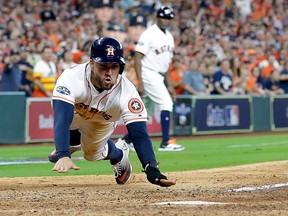 Houston Astros' George Springer scores on teammate Alex Bregman's hit during the seventh inning in Game 1 of an American League Division Series baseball game against the Cleveland Indians, Friday, Oct. 5, 2018, in Houston.