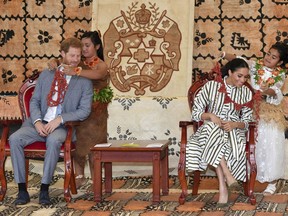 Britain's Prince Harry and Meghan, Duchess of Sussex are given flower garlands at the Fa'onelua Convention Centre inNuku'alofa, Tonga, Friday, Oct. 26, 2018. Prince Harry and his wife Meghan are on day 11 of their 16-day tour of Australia and the South Pacific.