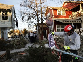 South Florida urban search and rescue specialist Chris Boyer removes a damaged American flag from a downed pole while checking for survivors of Hurricane Michael in Mexico Beach, Fla., Friday, Oct. 12, 2018.