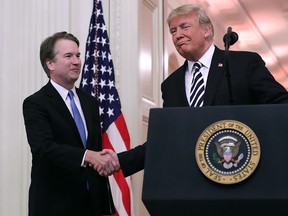 U.S. Supreme Court Justice Brett Kavanaugh (left) shakes hands with President Donald Trump during Kavanaugh's ceremonial swearing in in the East Room of the White House October 8, 2018 in Washington, DC. (Chip Somodevilla/Getty Images)