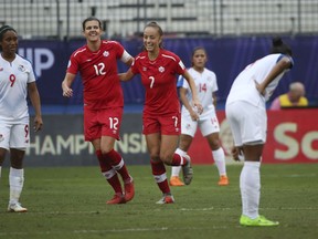 Panama midfielder Karla Riley (9) stands nearby as Canada midfielder Julia Grosso (7) celebrates with forward Christine Sinclair after Sinclair scored a goal during the first half of a soccer match at the semifinals of the CONCACAF women's World Cup qualifying tournament in Frisco, Texas, Sunday, Oct. 14, 2018.