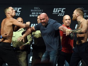 UFC President Dana White (C) separates mixed martial artist Nate Diaz (L) and UFC featherweight champion Conor McGregor (R) as they face off during their weigh-in for UFC 202 at MGM Grand Conference Center on Aug. 19, 2016 in Las Vegas.
