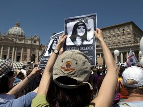 FILE - In this May 27, 2012, file photo, demonstrators hold pictures of Emanuela Orlandi reading "march for truth and justice for Emanuela" during Pope Benedict XVI's Regina Coeli prayer in St. Peter's square, at the Vatican.