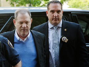In this May 25, 2018 file photo, NYPD Detective Nicholas DiGaudio, right, escorts Harvey Weinstein into court in New York.