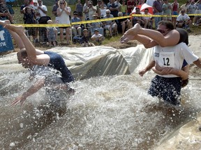 In this July 21, 2001 file photo, contestants run through water during the 2nd annual North American Wife Carrying Championships in Newry, ME. (Darren McCollester/Getty Images)