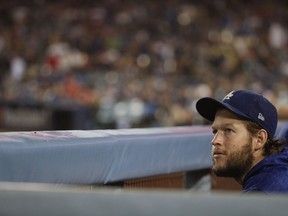 Los Angeles Dodgers starting pitcher Clayton Kershaw watches from the dugout during the ninth inning in Game 5 of the World Series baseball game against the Boston Red Sox on Sunday, Oct. 28, 2018, in Los Angeles.