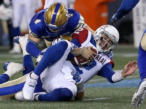 Montreal Alouettes QB Johnny Manziel is stopped on a run by Winnipeg Blue Bombers LB Adam Bighill (4) and Jovan Santos-Knox (bottom) during CFL action against the  in Winnipeg on Fri., Sept. 21, 2018. Kevin King/Winnipeg Sun/Postmedia Network