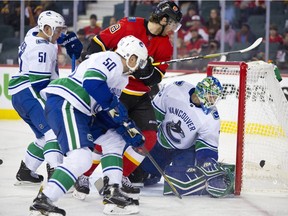 Calgary Flames James Neal, middle, tries to score on Vancouver Canucks goalie Thatcher Demko during their game against at the Scotiabank Saddledome in Calgary, Alta. on Saturday September 22, 2018. Leah Hennel/Postmedia