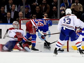 Rangers' Neal Pionk scores the winning goal past Habs goalie Carey Price while Max Domi looks on during third period Tuesday night in New York.