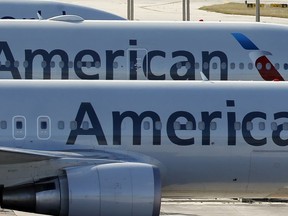 FILE - In this Monday, Nov. 6, 2017, file photo, a pair of American Airlines jets are parked on the airport apron at Miami International Airport in Miami.