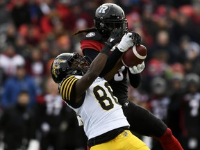 Ottawa Redblacks' Rico Murray (3) gets his hands on the ball as Hamilton Tiger-Cats' Bralon Addison (86) fails to catch it during first-half CFL East Division Final football game action in Ottawa, Sunday, Nov. 18, 2018. (Justin Tang/The Canadian Press via AP)