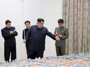 This undated picture released from North Korea's official Korean Central News Agency (KCNA) on November 16, 2018 shows North Korean leader Kim Jong Un (2nd R) examining and guiding the master plan for Sinuiju City at an undisclosed location. (Photo by KCNA VIA KNS/AFP)