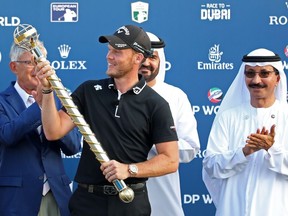 Danny Willett of England (2nd-L) poses with the DP World Tour trophy during day four of the DP World Tour Championship at Jumeirah Golf Estates golf course in Dubai on November 18, 2018.