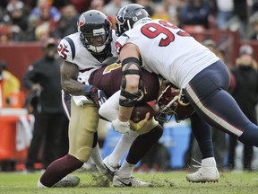 Redskins quarterback Alex Smith broke his ankle while being sacked by Texans defensive end J.J. Watt and strong safety Kareem Jackson during NFL action Nov. 18, 2018 in Landover, Md.
