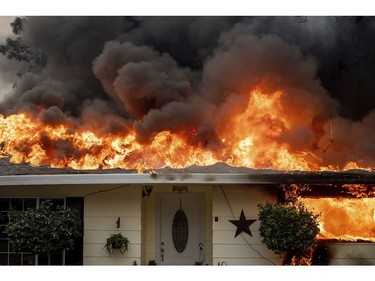 Flames consume a home as the Camp Fire tears through Paradise, Calif., on Thursday, Nov. 8, 2018.