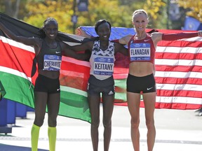 Second place finisher Vivian Cheruiyot of Kenya, left, first place finisher Mary Keitany of Kenya, center, and third place finisher Shalane Flanagan of the United States pose for a picture at the finish line of the New York City Marathon in New York, Sunday, Nov. 4, 2018. (AP Photo/Seth Wenig)