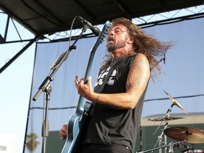 FILE - In this Aug. 26, 2018 file photo, Dave Grohl of the Foo Fighters performs at the Cal Jam 18 Pop-Up Event at the Hollywood Palladium in Los Angeles.  Grohl doesn't want firefighters battling the California wildfires to go hungry. He served his Backbeat Barbeque at Fire Station 68 in Calabasas on Monday, Nov. 12, 2018.   Firefighters, who have been battling the Woolsey fire, thanked Grohl on Instagram.