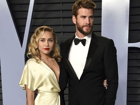 In this March 4, 2018 file photo, Miley Cyrus, left, and Liam Hemsworth arrive at the Vanity Fair Oscar Party in Beverly Hills, Calif.