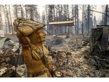 A statue rests amid a charred lot as the Camp Fire tears through Paradise, Calif., on Thursday, Nov. 8, 2018.