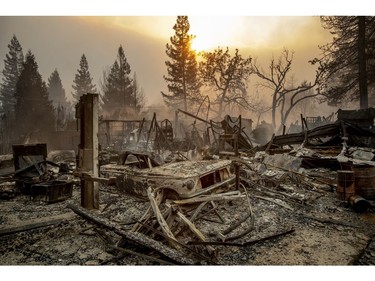 A vintage car rests among debris as the Camp Fire tears through Paradise, Calif., on Thursday, Nov. 8, 2018.