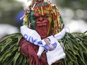 A supporters of Cameroon President Paul Biya during an election campaign rally in Yaounde, Cameroon, Friday, Oct. 5, 2018. (AP Photo/Sunday Alamba)