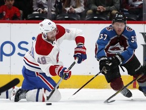 Montreal Canadiens right wing Logan Shaw, left, fires the puck past Colorado Avalanche left wing J.T. Compher in the second period of an NHL hockey game Wednesday, Feb. 14, 2018, in Denver.