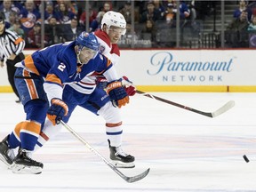 New York Islanders defenseman Nick Leddy, left, and Montreal Canadiens left wing Max Domi, right, chase a loose puck in the first period of an NHL hockey game, Monday, Nov. 5, 2018, in New York.