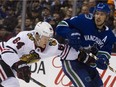 Canucks' defenceman Michael Del Zotto manhandles David Kampf of the Chicago Blackhawks during Wednesday's NHL action in Vancouver. The Canucks beat the visitors 4-2.