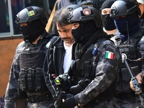 Agents of the Criminal Investigation Agency and soldiers of the Mexican army escort senior lieutenant of U.S. jailed drug lord, Joaquin "Chapo" Guzman, Damaso Lopez (centre) after arresting him, in Mexico City on May 2, 2017. (STRSTR/AFP/Getty Images)