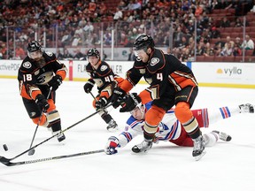 New York Rangers' Jimmy Vesey, bottom, dives for the puck against Anaheim Ducks' Cam Fowler as Ducks' Patrick Eaves, left, and Isac Lundestrom, background centre, of Sweden, watch during the first period of an NHL  game Thursday, Nov. 1, 2018, in Anaheim, Calif.