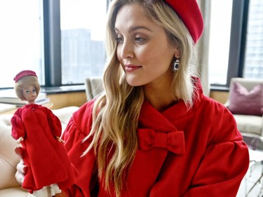 In this Nov. 5, 2018 photo, model Kelsey Elliott holds a Barbie doll while wearing a matching outfit from designer Katie Echeverry in New York. Echeverry's company, Unique Vintage, based in Burbank, California, is the first Mattel collaboration for a fashion line based on Barbie outfits.