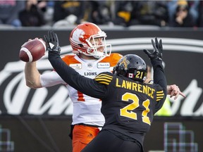 B.C. Lions quarterback Travis Lulay (14) is pressured by Hamilton Tiger-Cats linebacker Simoni Lawrence (21) during first half CFL Football division semifinal game action in Hamilton, Ont. on Sunday, November 11, 2018.