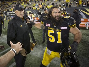 Ticats centre Mike Filer, celebrating a win with head coach June Jones, feels that despite a long list of injuries on offence, the team is right where it should be for Sunday’s East final.