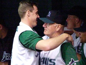 In this Aug. 12, 2001 file photo, Tampa Bay Devil Rays pitching coach Bill Fischer gets a hug from pitcher Tanyon Sturtze during the Devil Rays game with the Minnesota Twins, in St. Petersburg, Fla.