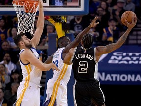 Kawhi Leonard, then of the San Antonio Spurs, shoots over Draymond Green (centre) and Andrew Bogut of the Golden State Warriors on April 7, 2016.