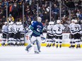 Los Angeles Kings' Jeff Carter, back left, trips over Vancouver Canucks goalie Jacob Markstrom, of Sweden, as Nikolay Goldobin (77), of Russia, watches during the second period of an NHL hockey game in Vancouver, on Tuesday Nov. 27, 2018.