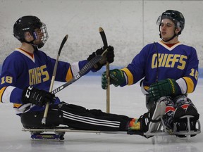 Humboldt Broncos hockey player Jacob Wassermann, left, and teammate Ryan Straschnitzki compare sticks during a sledge hockey scrimmage at the Edge Ice Arena in Littleton, Colo., on Friday, Nov. 23, 2018.